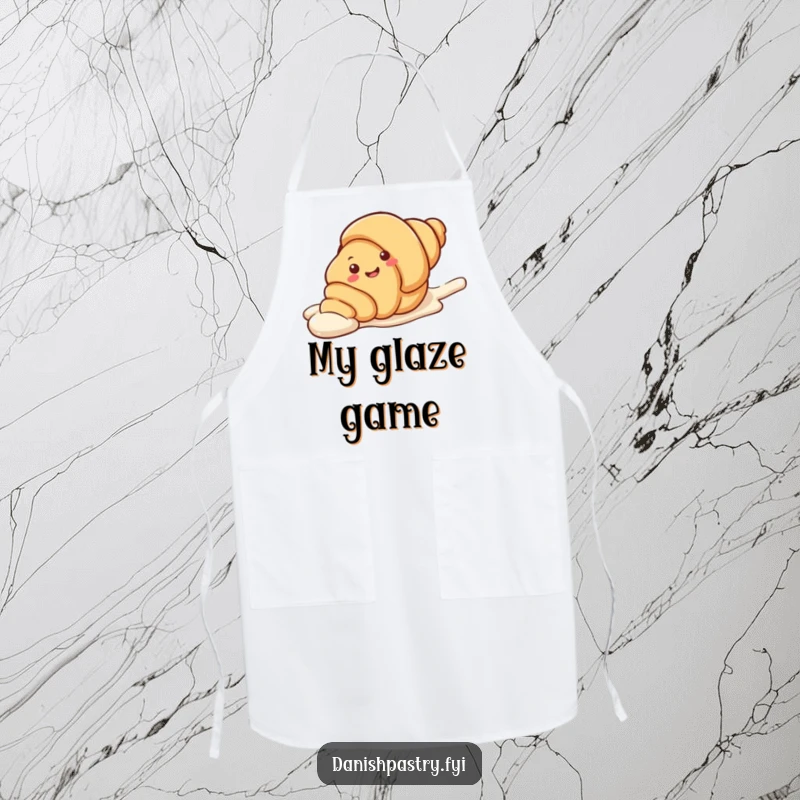 Funny Apron with a smiling croissant character playfully sliding down a streak of icing. A sweet and humorous kitchen accessory.