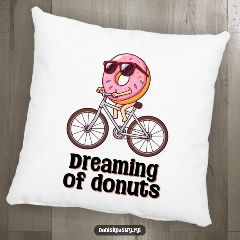 Funny donut wearing sunglasses riding a bicycle made of icing streaks, a soft and humorous pillow for ultimate comfort and laughs.