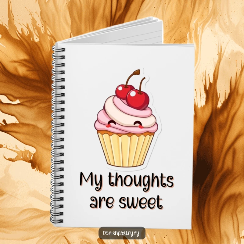 Funny cupcake with frosting bouncing a large cherry, a sweet notebook for writing and planning.